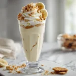 Thick banana pudding milkshake topped with whipped cream and wafers