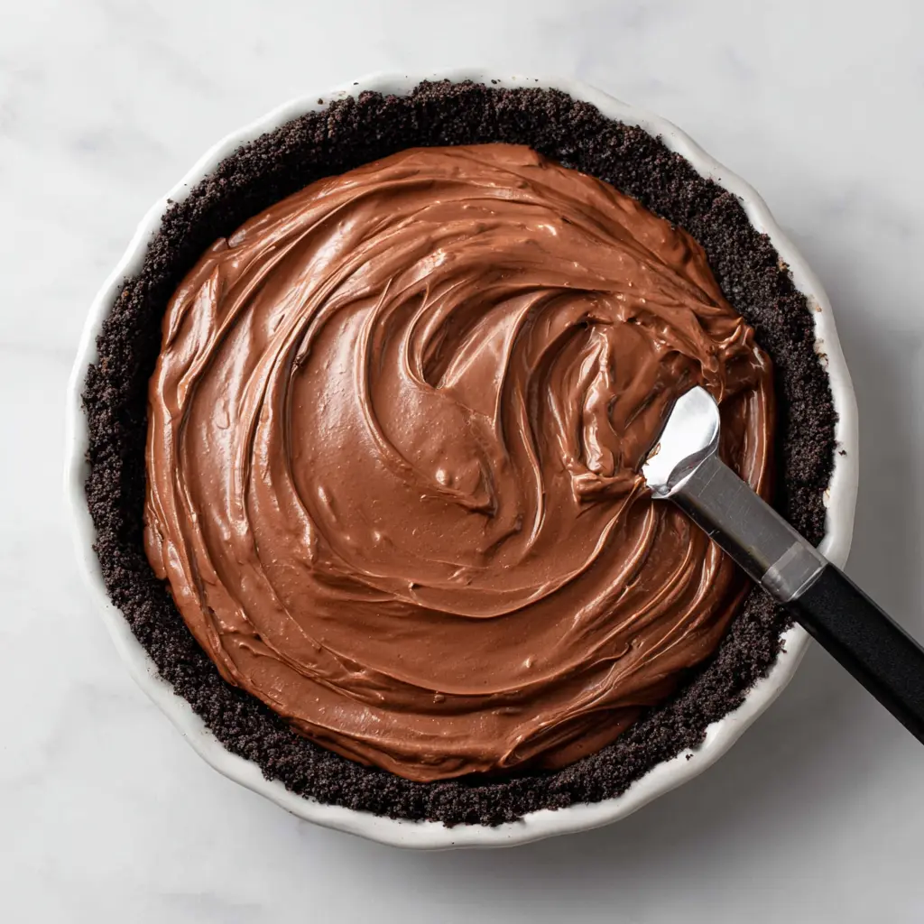 Hershey Bar icebox pie with smooth chocolate filling spread in a cookie crust.