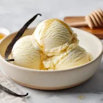 Close-up of a scoop of ninja creami vanilla ice cream recipe showing vanilla bean specks and glossy creamy texture.