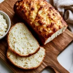 Sliced bread using cottage cheese on a marble bench with a soft fluffy crumb and golden crust .